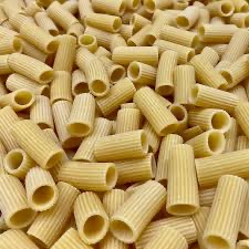 Fresh ridged rigatoni tubes on a light surface.