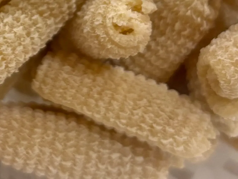 Close-up of fresh semolina gnocchi, short ridged shells with curled edges.